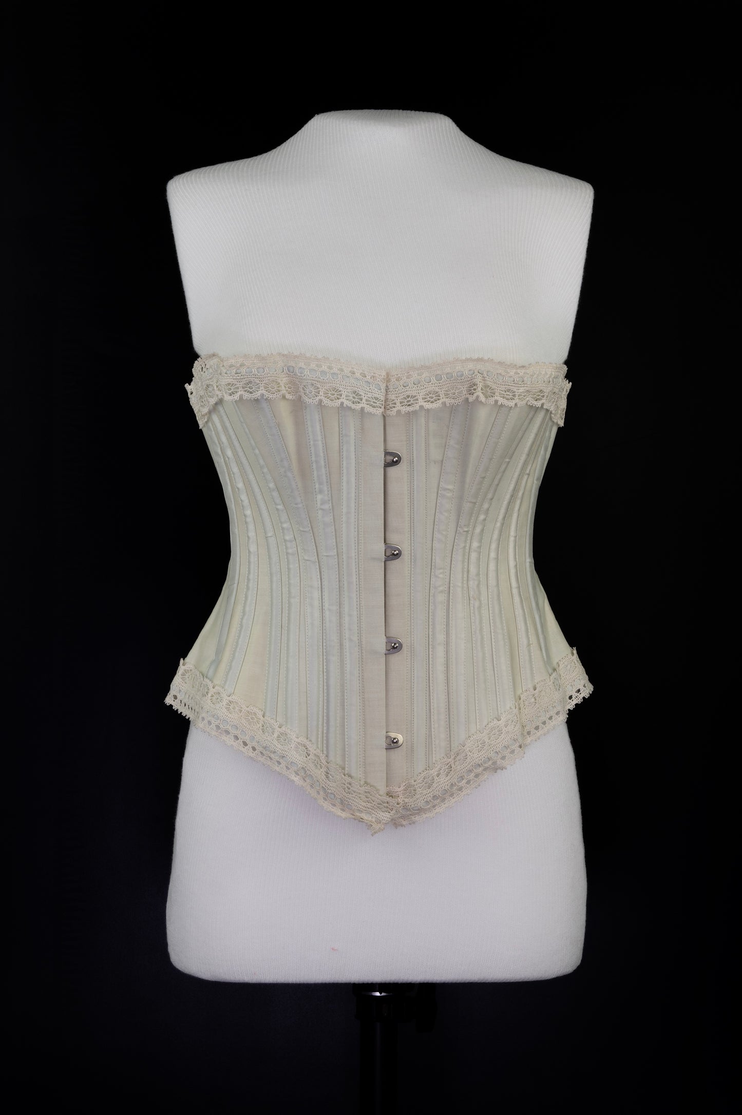 Beige corset on a mannequin against a black background