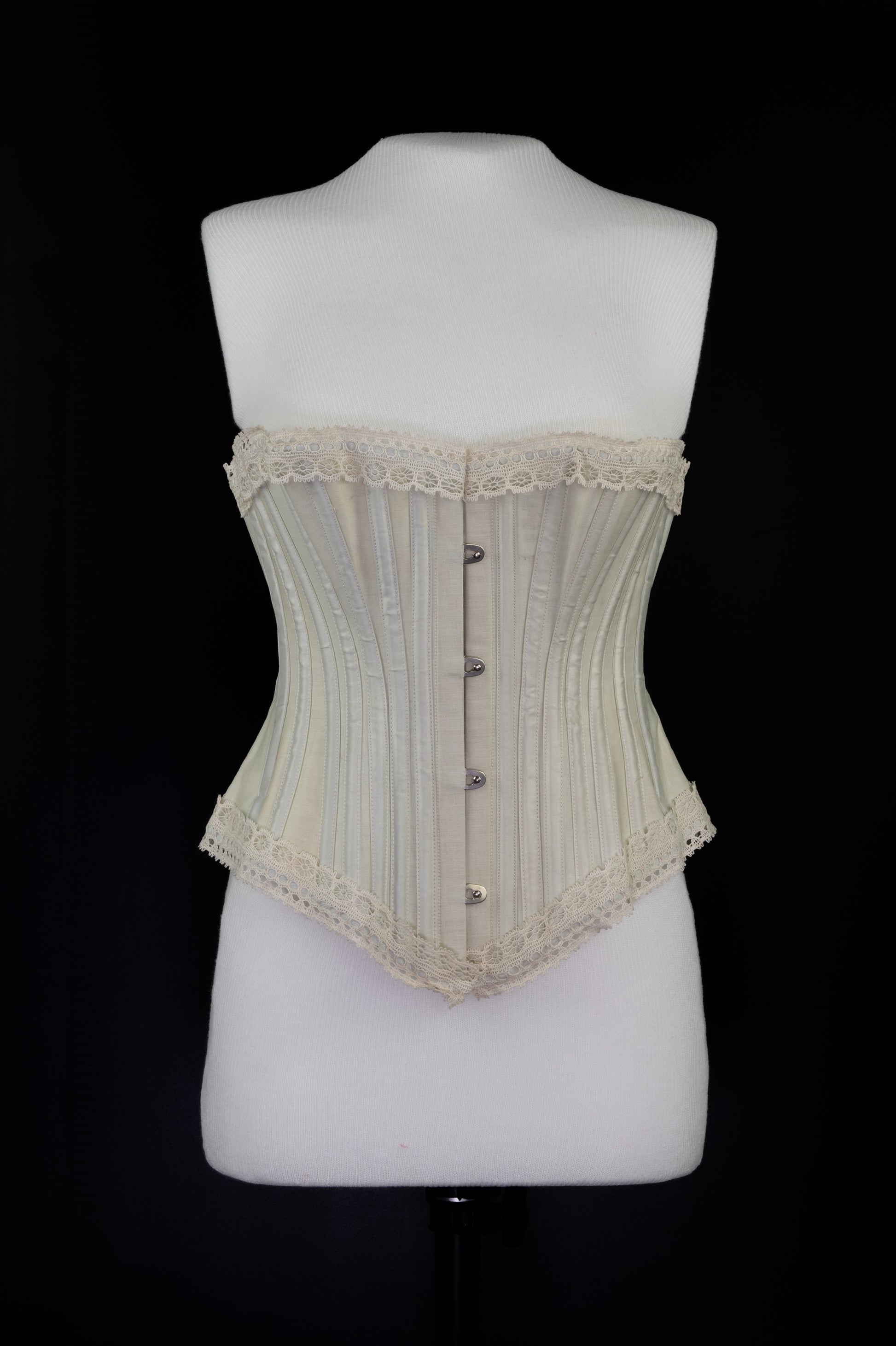 Beige corset on a mannequin against a black background