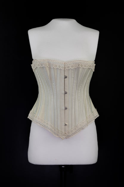 Beige corset on a mannequin against a black background