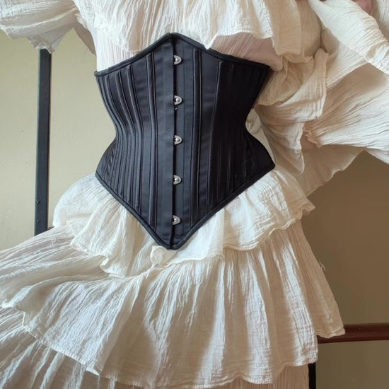 video of a black corset on a white dress