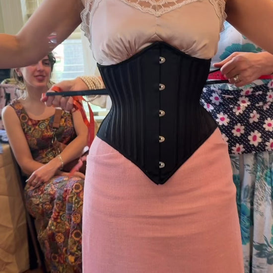 video of corset over a pink skirt and top
