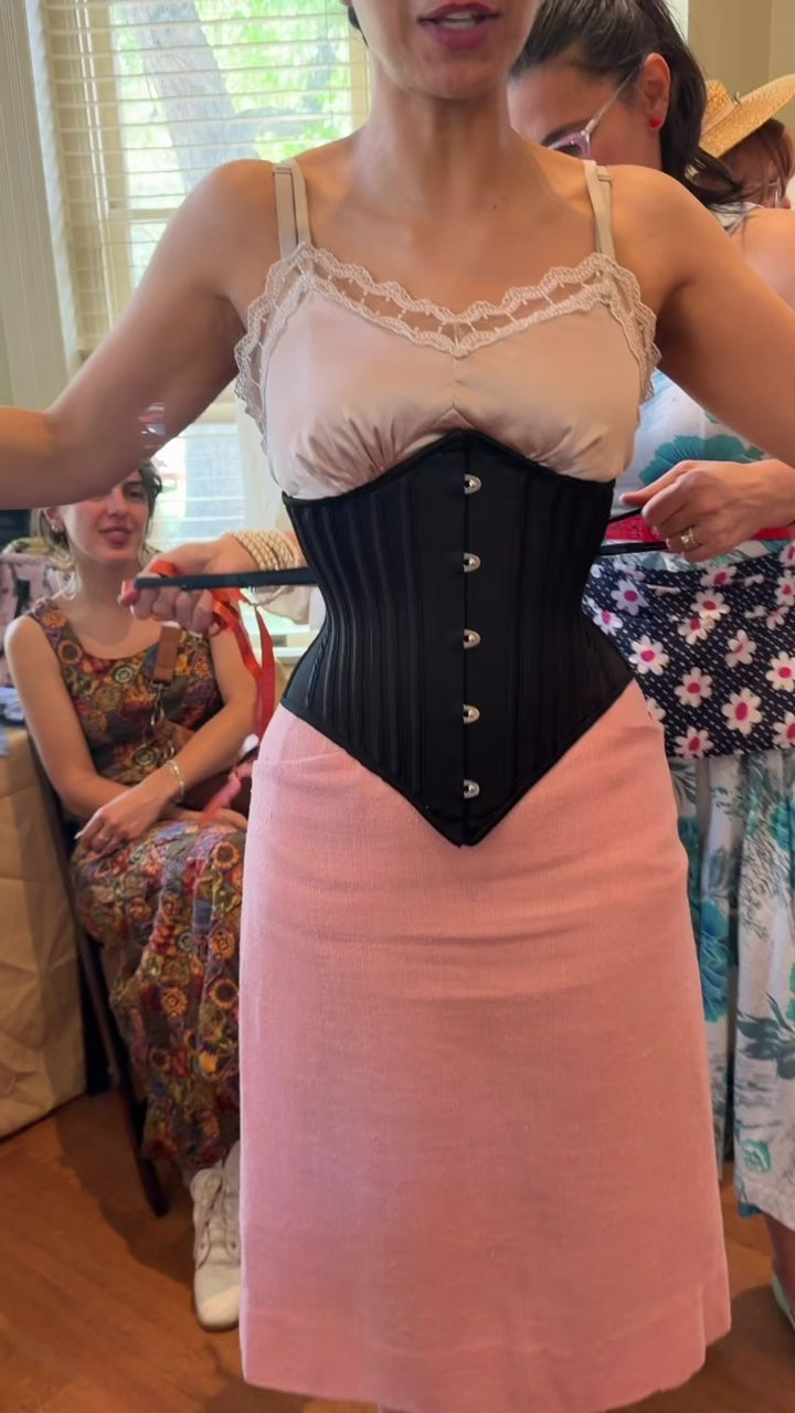 video of corset over a pink skirt and top