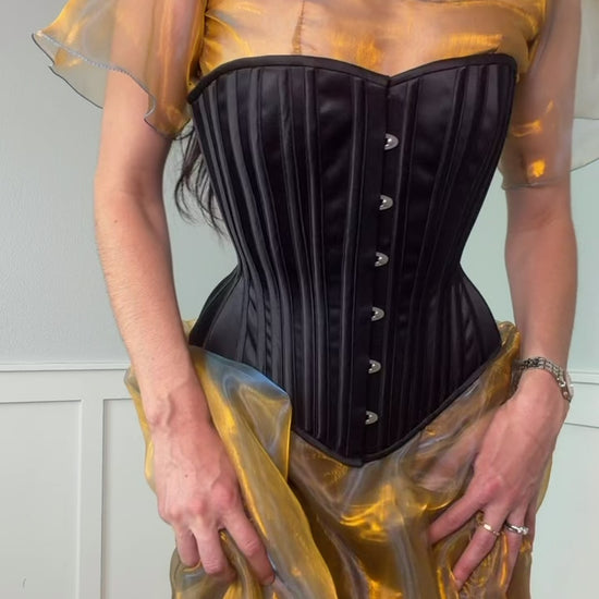 Video of woman wearing black corset over yellow dress
