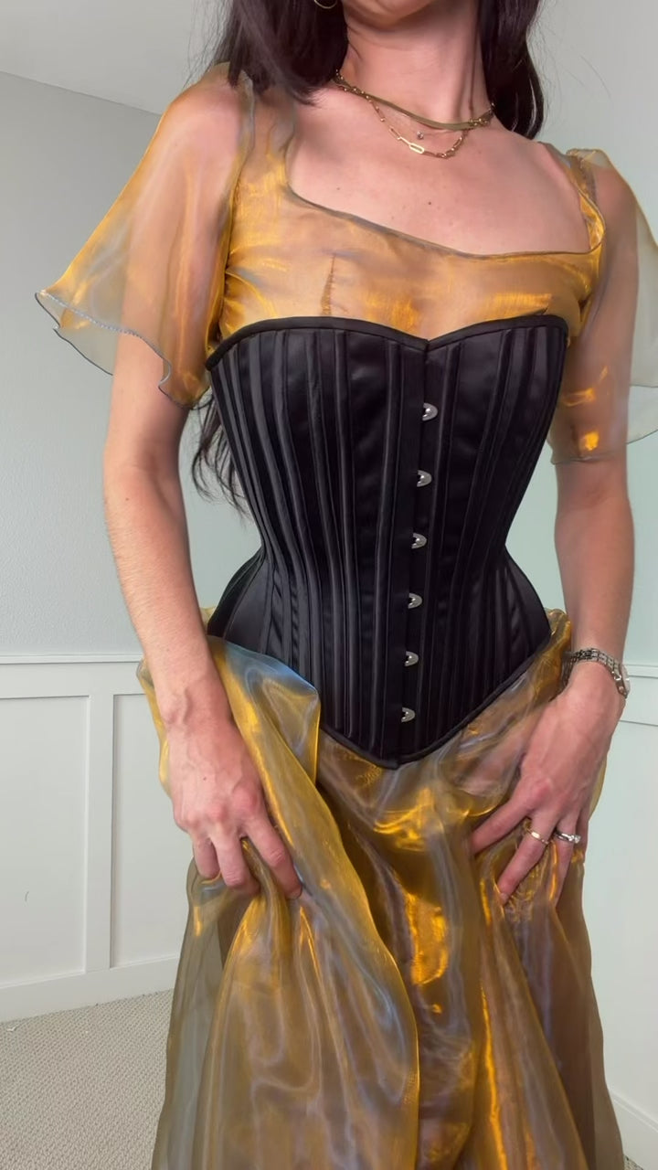 Video of woman wearing black corset over yellow dress