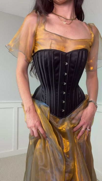 Video of woman wearing black corset over yellow dress
