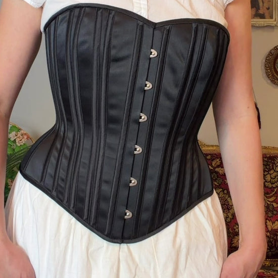 video of a woman in a black corset over a white chemise and it looks really, really good