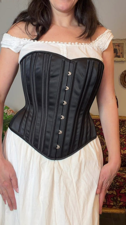 video of a woman in a black corset over a white chemise and it looks really, really good